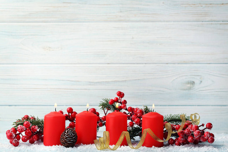 木桌上有冷杉树枝和浆果的圣诞蜡烛