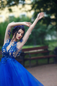 美丽的黑发女人的肖像，带蓝色皇冠的蕾丝连衣裙