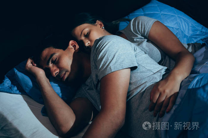 这对熟睡的夫妇在床上放松.夜间时间