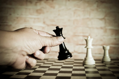 商人手中移动象棋人物赢得比赛。 商业战略成功理念。