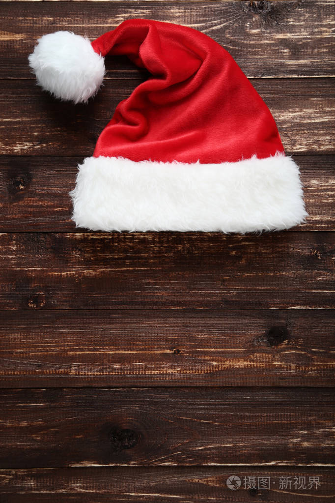 棕色木桌上的圣诞老人帽子