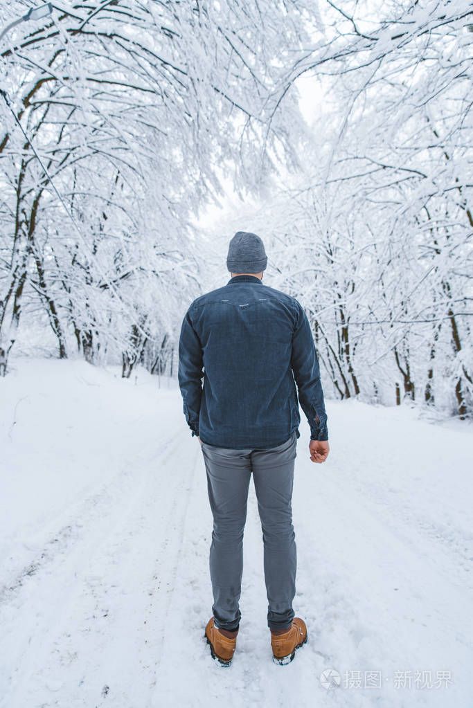 男子站在森林中的雪道