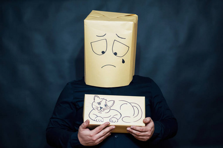 一个人手里拿着一只小猫.这张脸表示极度失望.泪滴下照片