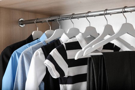 s clothes hanging in wardrobe, closeup