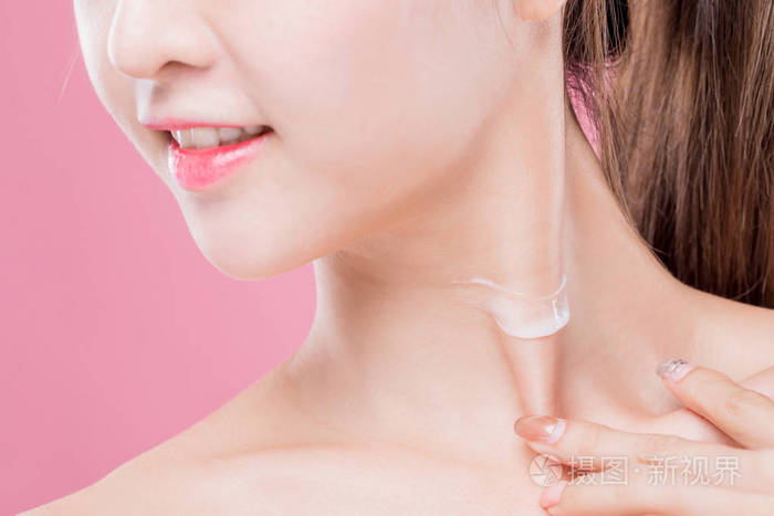 美女在脖子上用奶油隔离粉红色背景