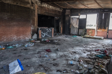 一个旧俱乐部废弃的破旧的内部,红砖墙上满是垃圾,地板上有一个破旧的