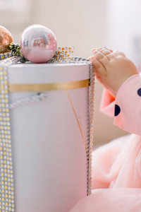 躺在圣诞礼物粉红色盒子上的女婴的小手