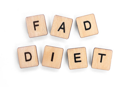 这个短语fad饮食在白色的背景上用木制字母瓷砖拼写。
