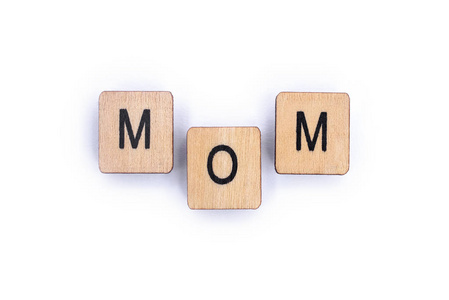 妈妈这个词在一个朴素的白色背景上用木制的字母瓷砖拼写。