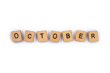 十月用木制字母瓷砖拼在一个普通的白色背景上。