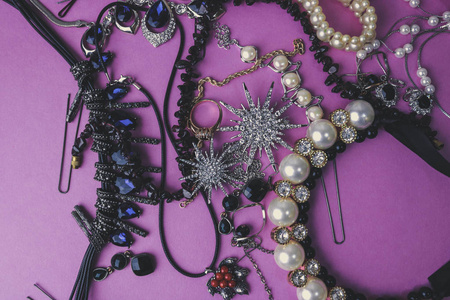 美丽珍贵的闪亮珠宝时尚迷人的珠宝套装, 项链, 耳环, 戒指, 链, 与珍珠和钻石在粉红色紫色背景的胸针。平面布局, 顶部视图