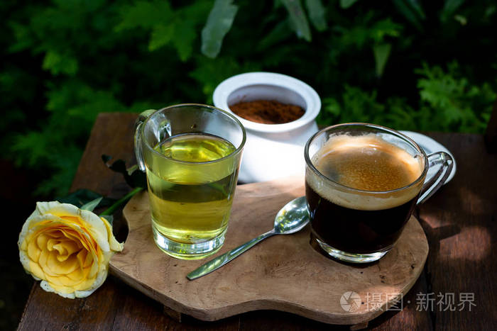 咖啡和茶在绿色花园的木桌上