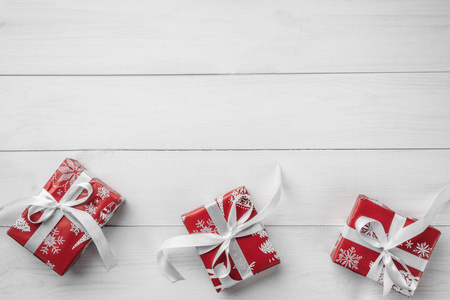 圣诞框架从节日礼物与红色丝带在白色木背景。圣诞节和快乐的新年卡。顶部视图, 平面布局, 复制空间