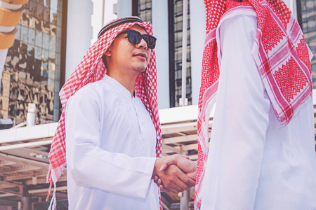 阿拉伯商人在建筑工地上与他的商业伙伴握手