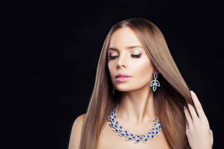 迷人的珠宝模特。 戴着钻石项链和蓝色宝石耳环的完美女人
