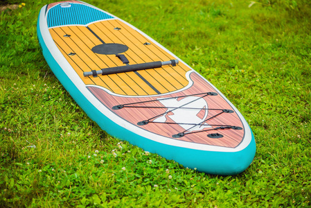 冲浪板躺在河边湖边或海边的草地上。