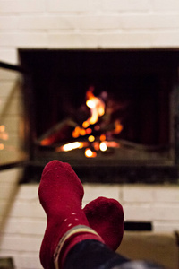 木头在家里舒适的壁炉里燃烧。 壁炉里着火了。 冬季和圣诞节假期的概念。
