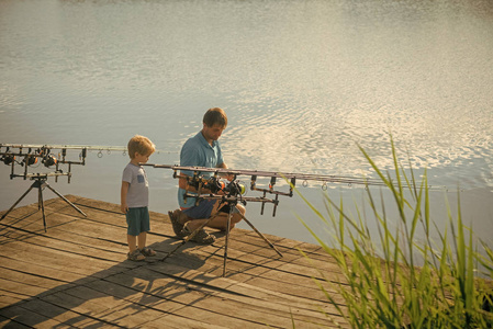 爸爸帮儿子钓鱼竿图片