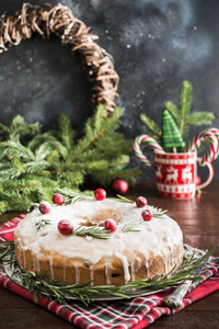 传统自制的圣诞蛋糕, 配上红莓和装饰板上的迷迭香
