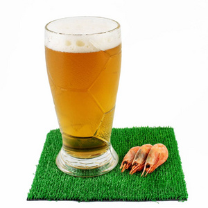 桌子上绿草上的啤酒和一些虾。