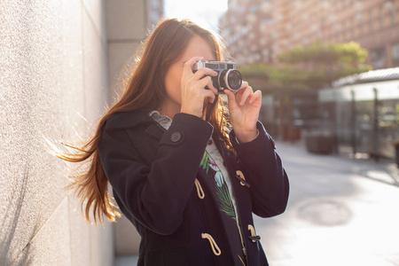 户外秋天微笑生活方式画像漂亮的年轻女子, 有乐趣在城市与照相机, 摄影师的旅行相片