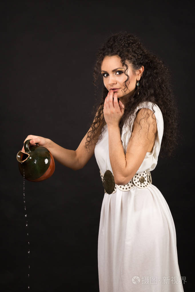 一个在希腊土加里从罐子里倒水的古雅女孩