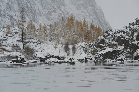 多云的早晨。 雪覆盖冬山湖俄罗斯西伯利亚阿尔泰山丘崖岭。