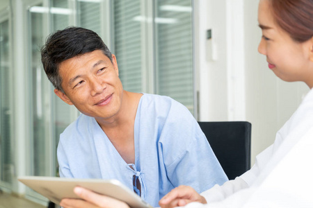 亚洲资深病人在办公室与医生协商时选择焦点