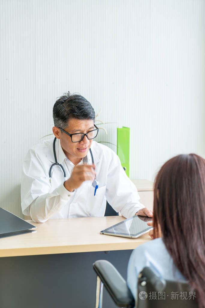 亚洲的医生和病人正坐在桌子旁咨询和讨论一些事情
