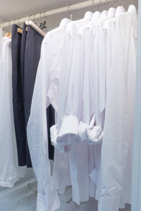 现代室内衣柜，衬衫和衣服在货架上。