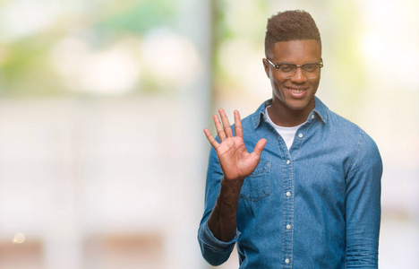 年轻的非裔美国人，在孤立的背景下，用手指第五，同时微笑，自信和快乐。