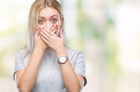 年轻的金发女人在孤立的背景下震惊地用手捂住嘴，因为错误。 秘密概念。