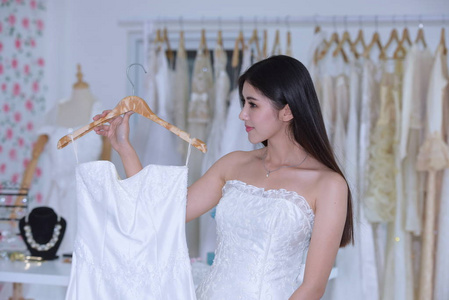 新娘来到更衣室测量新娘礼服的准备情况。女裁缝婚礼顾问和新娘试穿婚纱，并在工作室自拍