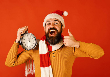 圣诞老人拿着显示竖起大拇指的旧钟。寒假概念