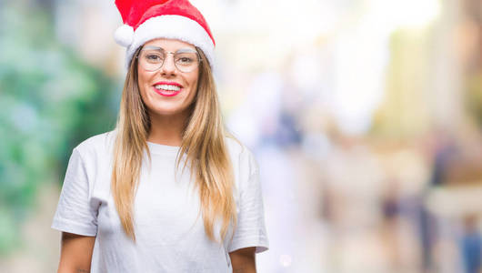 年轻漂亮的女人戴着圣诞帽，在孤立的背景上，脸上带着快乐和凉爽的微笑。 幸运的人。