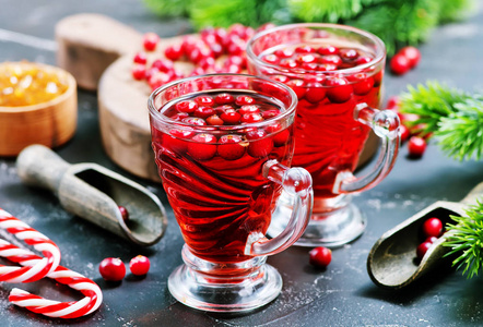 近距离观看圣诞糖果罐和蔓越莓饮料与浆果在黑暗的桌面
