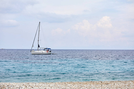 地中海的帆船。 旅行的概念和积极的生活方式。 石滩和温暖的大海
