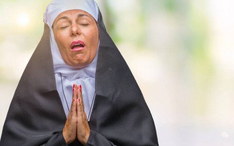 中年高级基督教天主教修女妇女在孤立的背景下乞讨和祈祷,双手一起