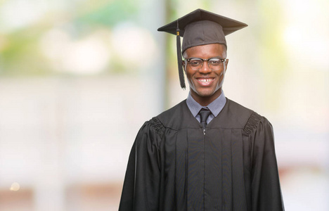 年轻毕业的非裔美国人，在孤立的背景下，脸上带着快乐和冷静的微笑。 幸运的人。