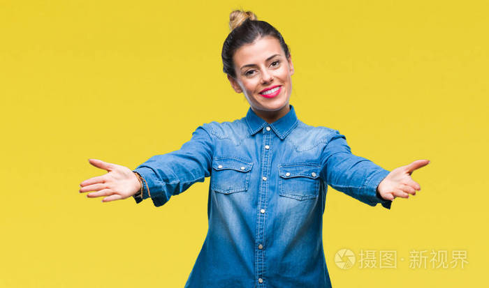 年轻漂亮的女人在孤立的背景上看着相机,张开双臂微笑着拥抱.
