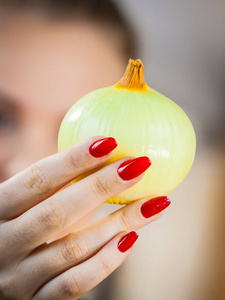 女人拿着健康的新鲜天然白葱。 健康饮食和节食的概念。