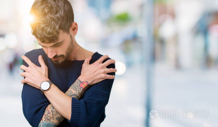 年轻的帅哥在孤立的背景下拥抱自己,快乐而积极的微笑自信. 自我爱和