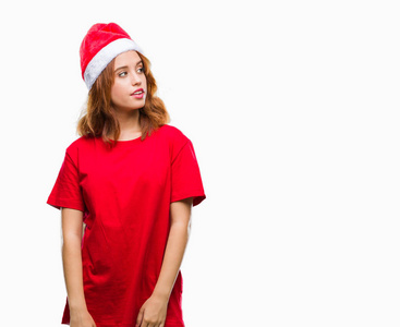 年轻漂亮的女人在孤立的背景上戴着圣诞帽，脸上带着微笑，自然 自信地笑着。