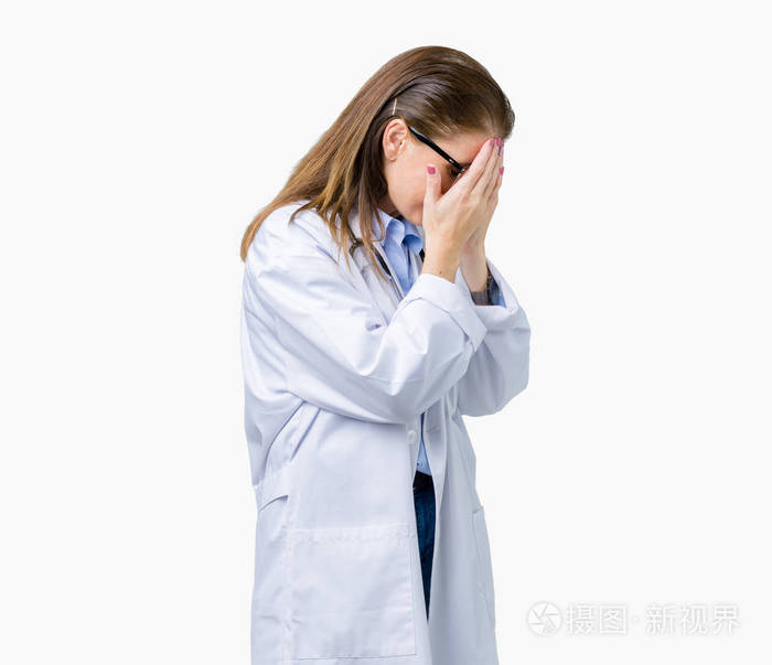 医生女人穿着医用外套,在孤立的背景上,悲伤的表情覆盖着脸,同时哭泣
