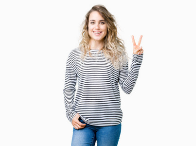 美丽的年轻金发女人穿着条纹毛衣，在孤立的背景上显示和指着第二个手指，同时微笑自信和快乐。