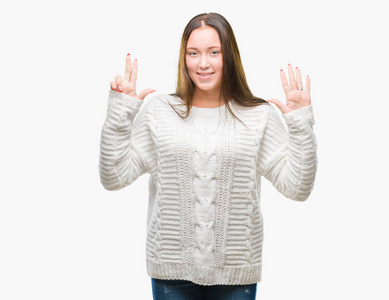 年轻美丽的白种人女人穿着冬天的毛衣，在孤立的背景下，用手指举着八号，微笑着自信和快乐。