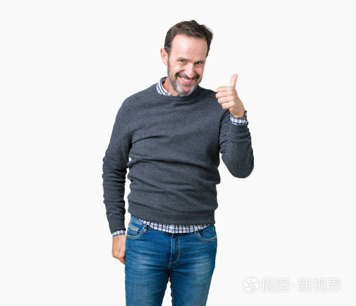 英俊的中年男子穿着一件毛衣在孤立的背景下用手做快乐的拇指向上的