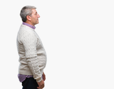 英俊的老人穿着冬天的毛衣,在孤立的背景下,看着侧面放松的轮廓,自然