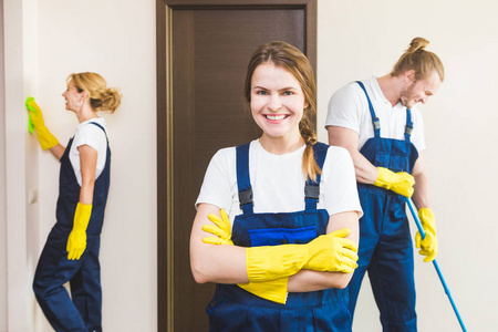 在工作过程中使用专业设备的清洁服务。专业的小厨房清洁, 沙发干洗, 窗户和地板清洗。穿制服工作服和橡胶手套的男人和女人