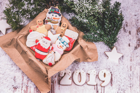 圣诞姜饼放在盒子里，节日礼物和木制背景上的圣诞装饰品和雪。 圣诞快乐，新年快乐，2019年。